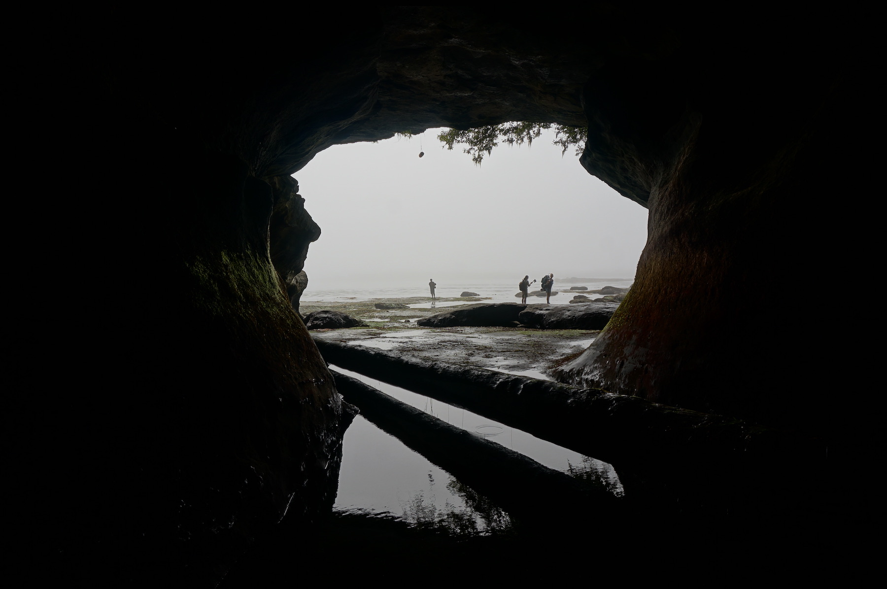 looking out of a cave, three people silhouettes